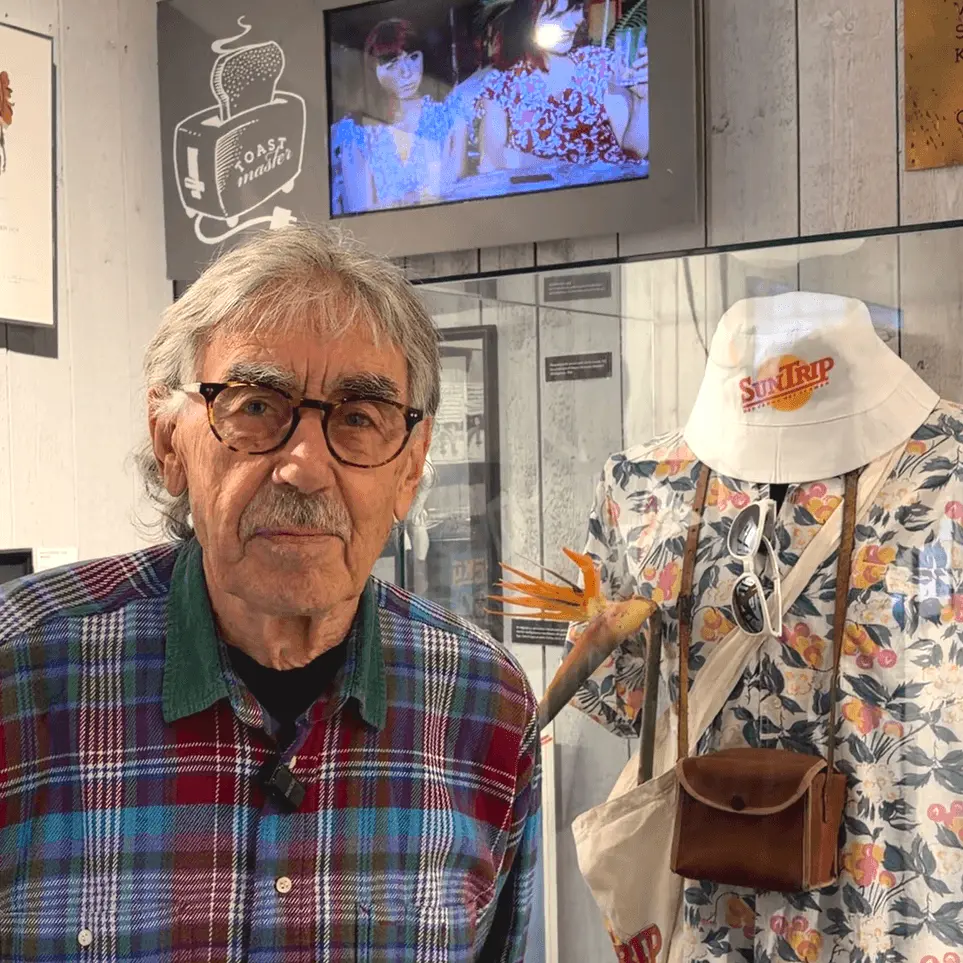 Lasse Åberg framför en monter med Stig-Helmers kläder från filmen Sällskapsresan